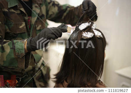 Male hairdresser applying drug to woman's hair 111819627