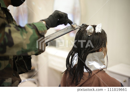 男理髮師在女人的頭髮上塗藥 111819661