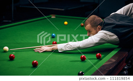 Dynamic shot of a player making shot, expressing energy and excitement for promoting billiards championship and local tournaments. Snooker game 111819854