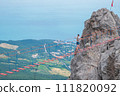 The girl walks on the suspension bridge between the tops of the mountains. 111820092