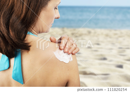 Middle aged caucasian female model applying sunscreen. Middle aged caucasian female model applying sunscreen. 111820254