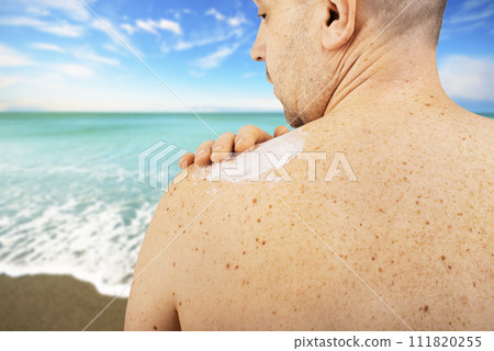 Middle aged caucasian male model applying sunscreen Middle aged caucasian male model applying sunscreen 111820255