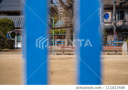An empty park seen through the gap between the playground equipment 111821486