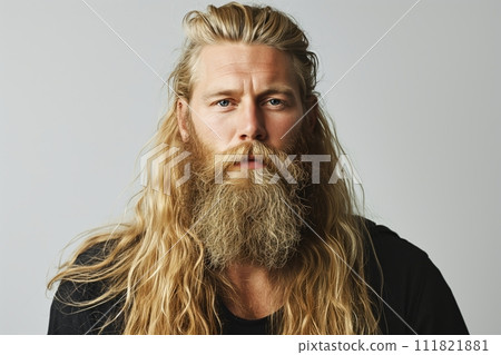 Handsome Norwegian bearded man is blond with long well groomed hair looking at camera Handsome Norwegian bearded man is blond with long well groomed hair looking at camera 111821881