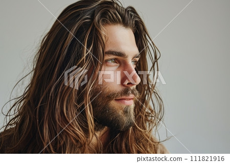 Profile portrait handsome Caucasian bearded brunette man contented expression and healthy long hair 111821916