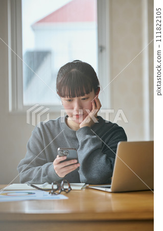 A young woman doing research on her smartphone 111822105