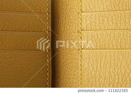 Part of a yellow leather wallet business card holder close-up. 111822385