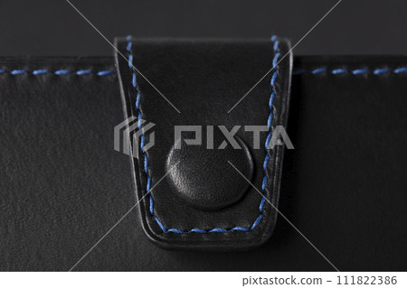 Black leather product closeup on a black background. 111822386