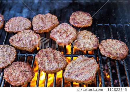 Grilling beef meat barbecue burgers on the barbecue grill using fire flame 111822543
