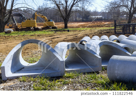 Concrete drainage, sewage, storm water pipes are stacked ready to installation at construction site 111822546