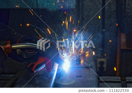 In factory, sparks are created as workers weld with gas argon to steel In factory, sparks are created as workers weld with gas argon to steel 111822550