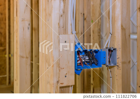 Electrical switch box is plastic wires attached to its wooden frame beams 111822706