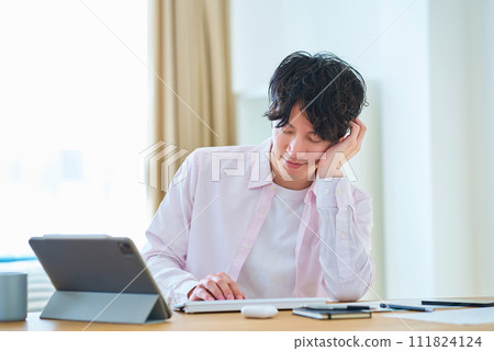 A man taking a break while operating a computer A man taking a break while operating a computer 111824124