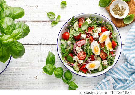 Egg and arugula fresh vegetable salad with feta cheese, top view 111825085