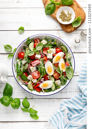 Egg and arugula fresh vegetable salad with feta cheese, top view Egg and arugula fresh vegetable salad with feta cheese, top view 111825089