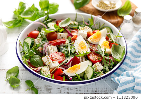 Egg and arugula fresh vegetable salad with feta cheese 111825090