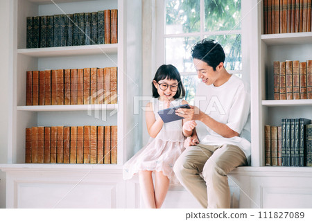 Daughter looking at tablet with dad 111827089