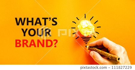 Branding what is your brand symbol. Concept words What is your brand on beautiful orange paper. Beautiful orange background. Businessman hand. Business branding what is your brand concept. Copy space. 111827229