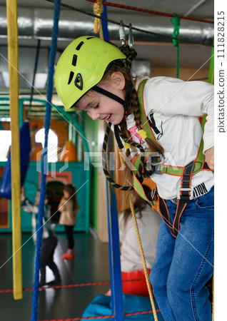 Happy girl passes the cableway, active recreation in the game room. 111828215