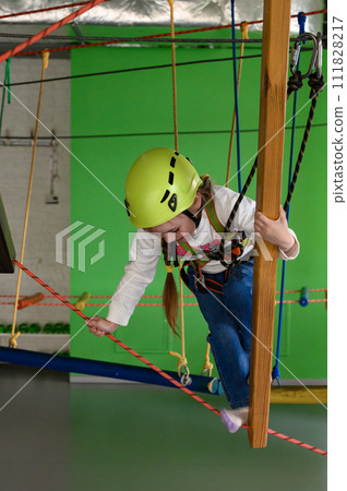 Happy girl passes the cableway, active recreation in the game room. 111828217