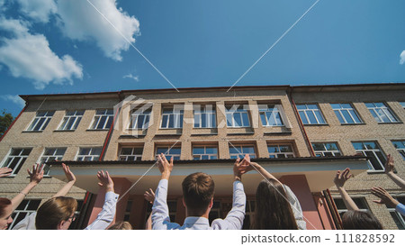 Graduates say goodbye to the school and wave goodbye. Graduates say goodbye to the school and wave goodbye. 111828592