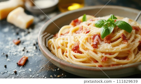 Delicious spaghetti carbonara with crispy bacon, grated cheese, and fresh basil on a rustic table Delicious spaghetti carbonara with crispy bacon, grated cheese, and fresh basil on a rustic table 111829639