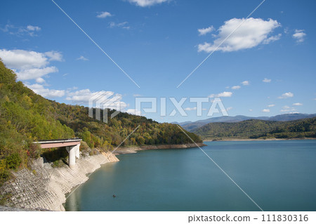Blue sky, beautiful lake surface and autumn trees at Chubetsu Dam in Hokkaido Blue sky, beautiful lake surface and autumn trees at Chubetsu Dam in Hokkaido 111830316