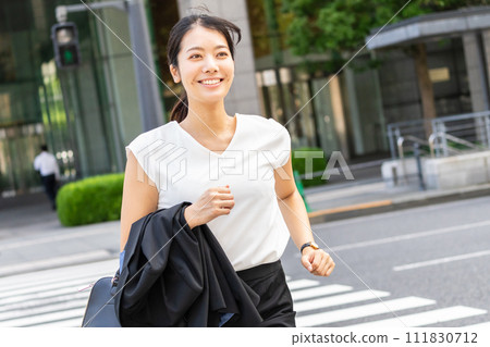 Business woman crossing a pedestrian crossing Business woman crossing a pedestrian crossing 111830712