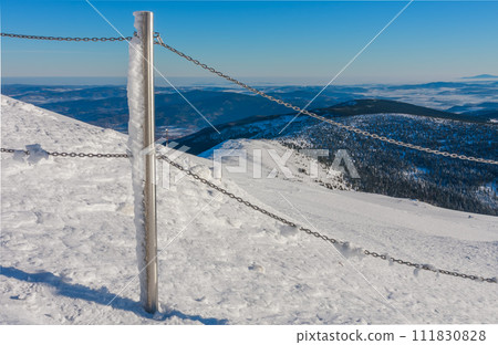 Steel railing tube with a chain, top of path to snezka from pink mountain, krkonose mountain, winter morning. Steel railing tube with a chain, top of path to snezka from pink mountain, krkonose mountain, winter morning. 111830828