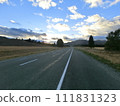 A straight road leading to the sunrise in a meadow in Mackenzie, New Zealand 111831323