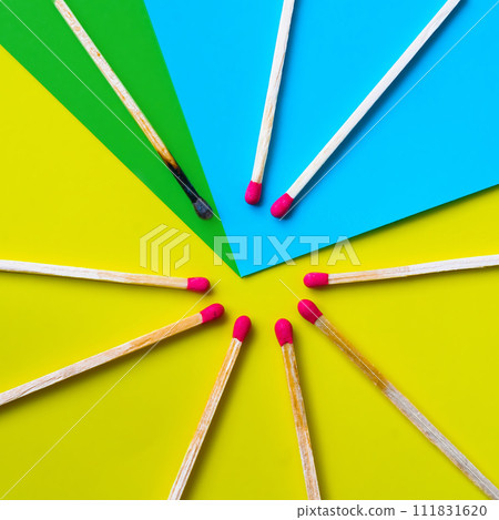 Success, defeat, achievement. The concept of happiness. Matches on a yellow background. Burnt dark match among normal matches. Burning match fire to its neighbors, a metaphor for ideas and inspiration 111831620
