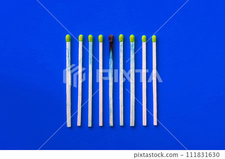 Success, defeat, achievement. The concept of happiness. Matches on a yellow background. Burnt dark match among normal matches. Burning match fire to its neighbors, a metaphor for ideas and inspiration 111831630