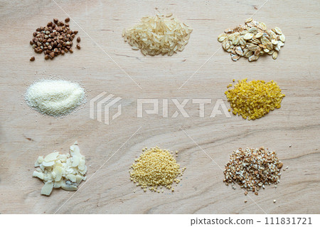 Assorted cereal grain porridge seeds set on a wooden background: buckwheat, rice, semolina, wheat, couscous, oatmeal Assorted cereal grain porridge seeds set on a wooden background: buckwheat, rice, semolina, wheat, couscous, oatmeal 111831721