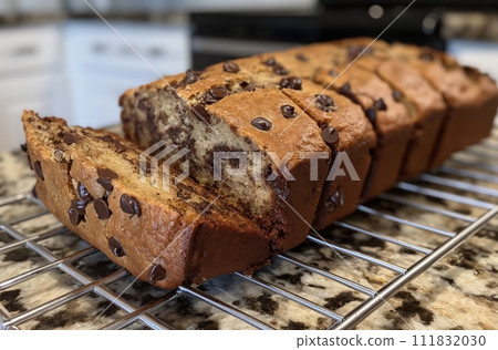 AI-generated content. Chocolate chip bread sliced and placed on a wire cooling rack, with a granite countertop in the background 111832030