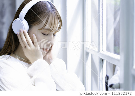 A young woman listening to music with headphones A young woman listening to music with headphones 111832172