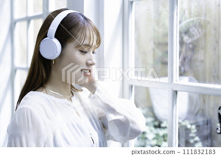 A young woman listening to music with headphones A young woman listening to music with headphones 111832183