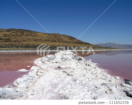Spiral Jetty long white salt path connecting land and sprial 111832256