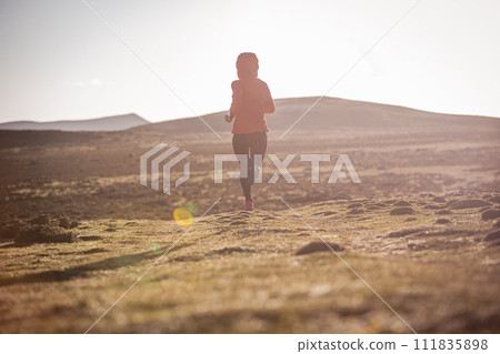 Woman trail runner cross country running to high altitude mountain peak 111835898
