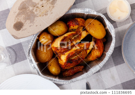 on table in baking dish is ready-to-eat fried chicken with potatoes in skin on table in baking dish is ready-to-eat fried chicken with potatoes in skin 111836695