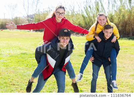 Happy teens compete with each other in park 111836764
