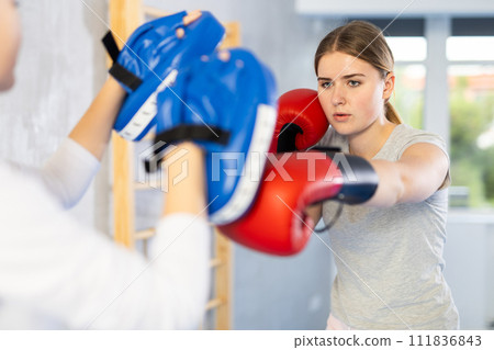 Teen girl in punch mitts boxing 111836843