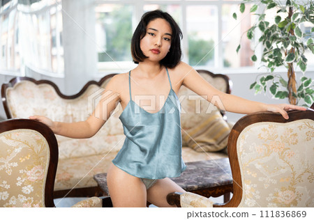 Slender girl in nightgown posing in luxurious home interior 111836869