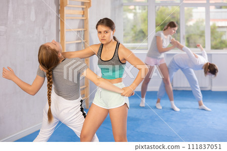 Girl and woman athletes in pair conduct training battle in oriental fighting technique 111837051