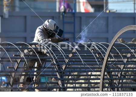鋼筋工人在新公寓中組裝用於樁基工程的鋼筋籠的工作場景 111837133