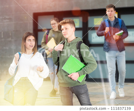 Carefree teen students boy and girl friendly talking Carefree teen students boy and girl friendly talking 111837139