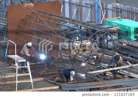 Work scene of a reinforcing bar worker assembling a reinforcing bar cage for pile foundation work in a newly built condominium Work scene of a reinforcing bar worker assembling a reinforcing bar cage for pile foundation work in a newly built condominium 111837165