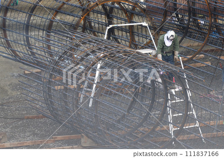 Work scene of a reinforcing bar worker assembling a reinforcing bar cage for pile foundation work in a newly built condominium 111837166