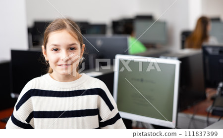 Interested teenage girl student standing in information technology classroom 111837399