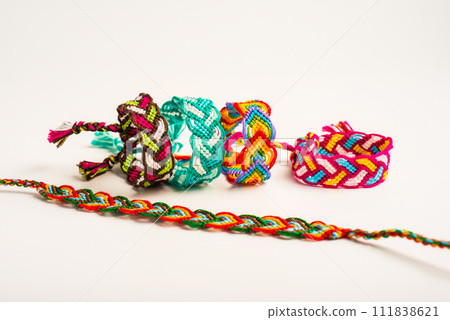 Multicolored woven DIY friendship bracelets handmade of embroidery bright thread with knots isolated on white background 111838621