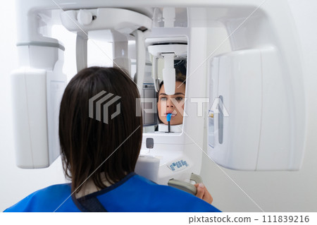 Close Up Portrait of Young Woman Undergoing Panoramic Teeth X-Ray at Dentists Office. Close Up Portrait of Young Woman Undergoing Panoramic Teeth X-Ray at Dentists Office. 111839216